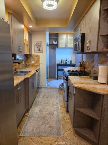 a kitchen with stainless steel appliances granite countertop a stove a sink and a refrigerator