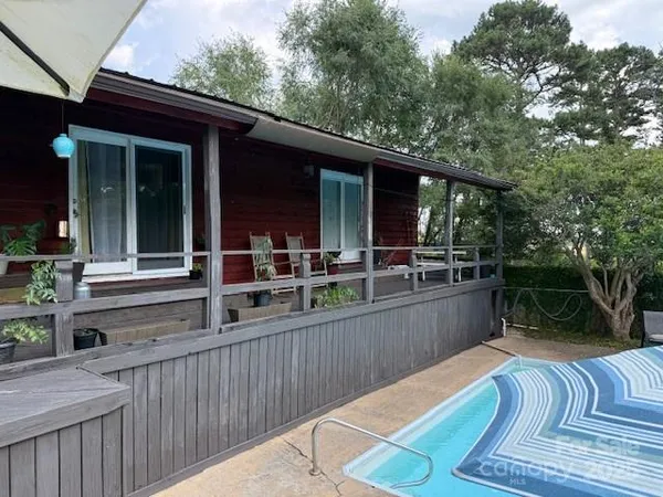 a kitchen with a refrigerator a sink dishwasher a dining table and chairs with wooden floor