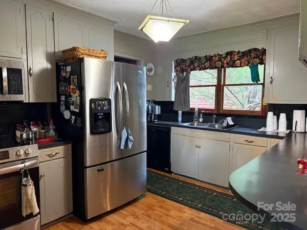 a kitchen with stainless steel appliances granite countertop a refrigerator and a sink