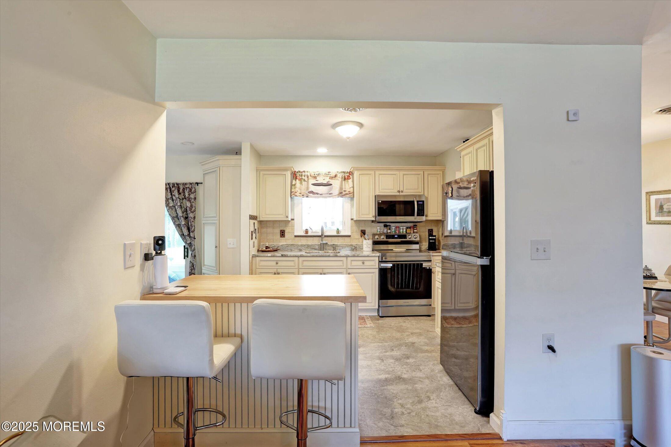 17 Churchill Road, Unit 71 Whiting, NJ 08759 - Photo 9 of 29 a kitchen with kitchen island granite countertop a refrigerator and a stove top oven