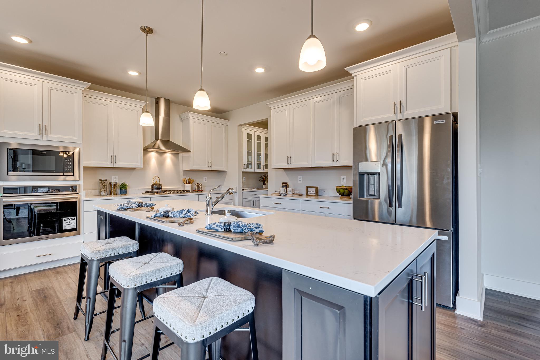 1337 German Driveway Hanover, MD 21076 - Photo 17 of 51 a kitchen with kitchen island a stove a table and chairs