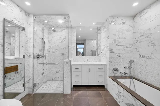 a spacious bathroom with a granite countertop sink mirror and shower