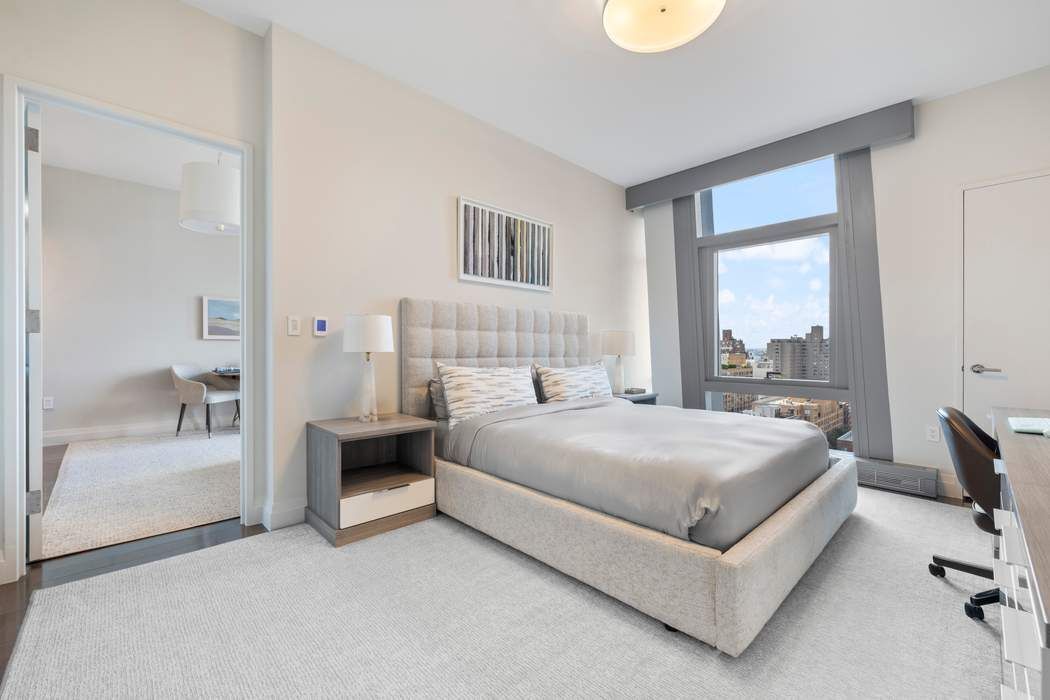 35 West 15th Street, Unit 13B Manhattan, NY 10011 - Photo 4 of 10 a bedroom with a bed and a large window