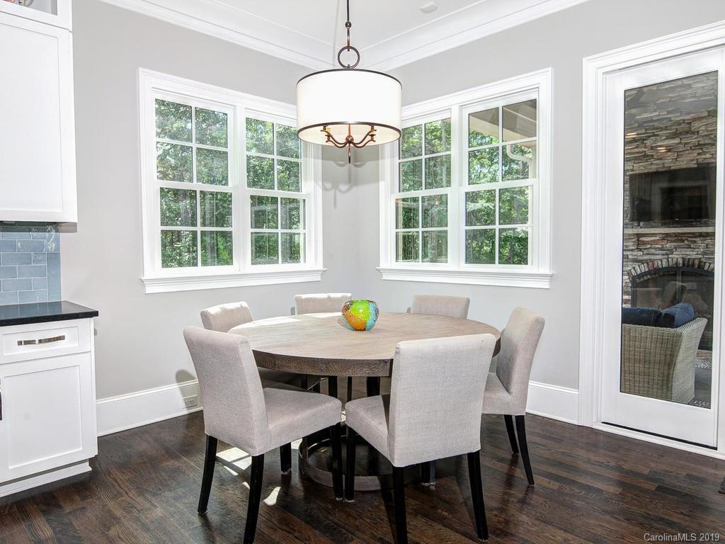 6237 Sharon Acres Road Charlotte, NC 28210 - Photo 11 of 48 a dining room with furniture a chandelier and wooden floor