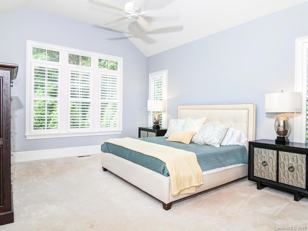 6237 Sharon Acres Road Charlotte, NC 28210 - Photo 17 of 48 a spacious bedroom with a bed and a lamp on dresser