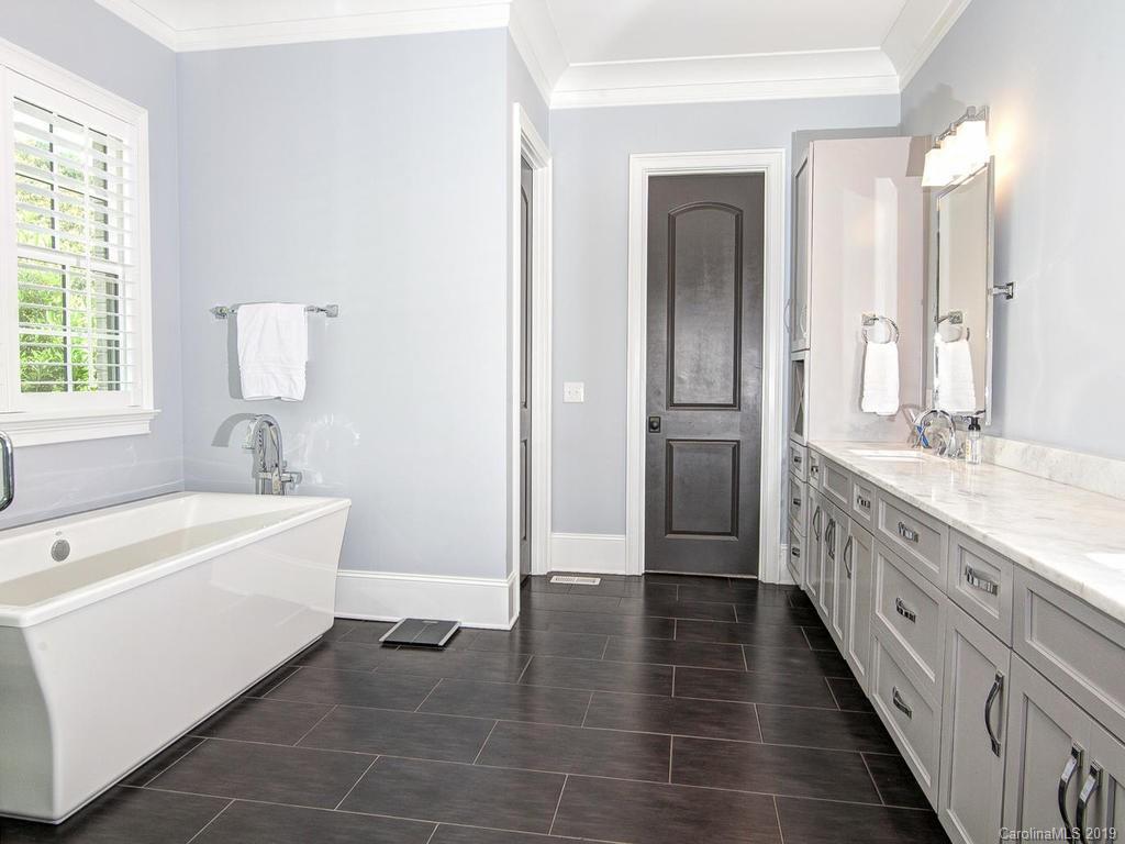 6237 Sharon Acres Road Charlotte, NC 28210 - Photo 19 of 48 a bathroom with a double vanity sink a mirror and a bathtub