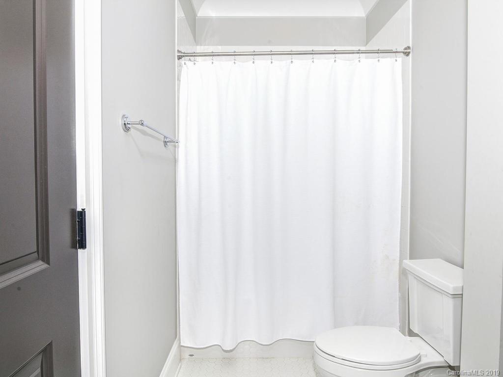 6237 Sharon Acres Road Charlotte, NC 28210 - Photo 29 of 48 a white toilet sitting next to a shower curtain