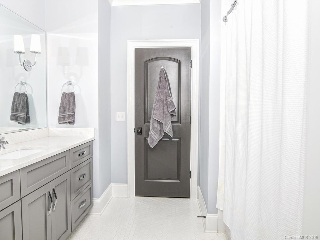 6237 Sharon Acres Road Charlotte, NC 28210 - Photo 32 of 48 a bathroom with a granite countertop sink a mirror and a shower