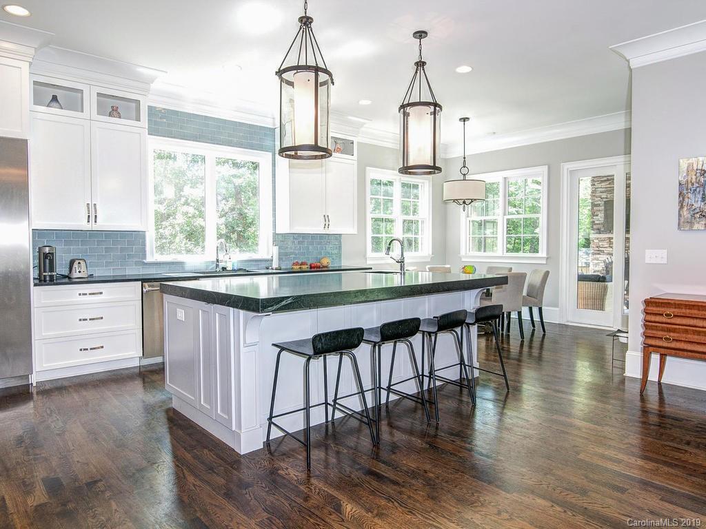 6237 Sharon Acres Road Charlotte, NC 28210 - Photo 6 of 48 a kitchen with stainless steel appliances granite countertop a stove and white cabinets with wooden floors
