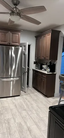 a kitchen with stainless steel appliances granite countertop a refrigerator a stove and a sink