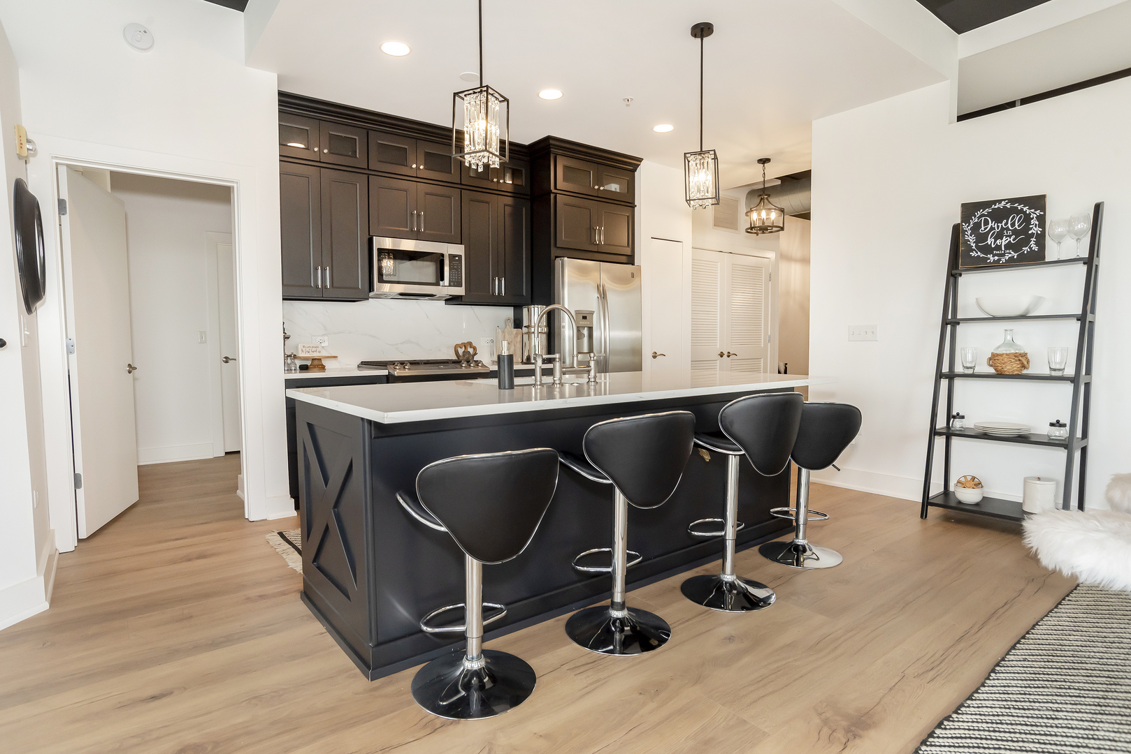 450 Village Center Drive, Unit 315 Burr Ridge, IL 60527 - Photo 5 of 21 a kitchen with stainless steel appliances granite countertop a sink dishwasher a refrigerator and a dining table with wooden floor