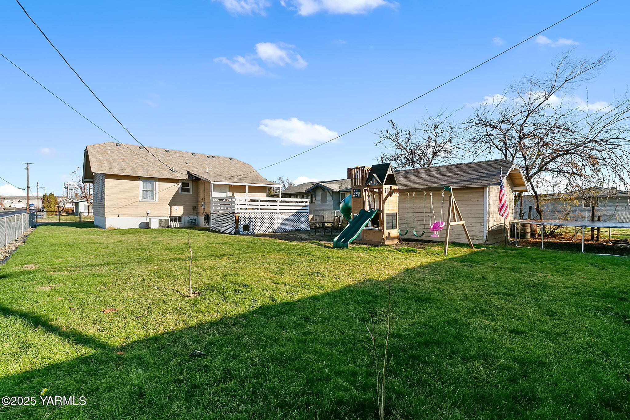 419 West 3rd Street Wapato, WA 98951 - Photo 4 of 19 a view of a house with a big yard potted plants and large tree