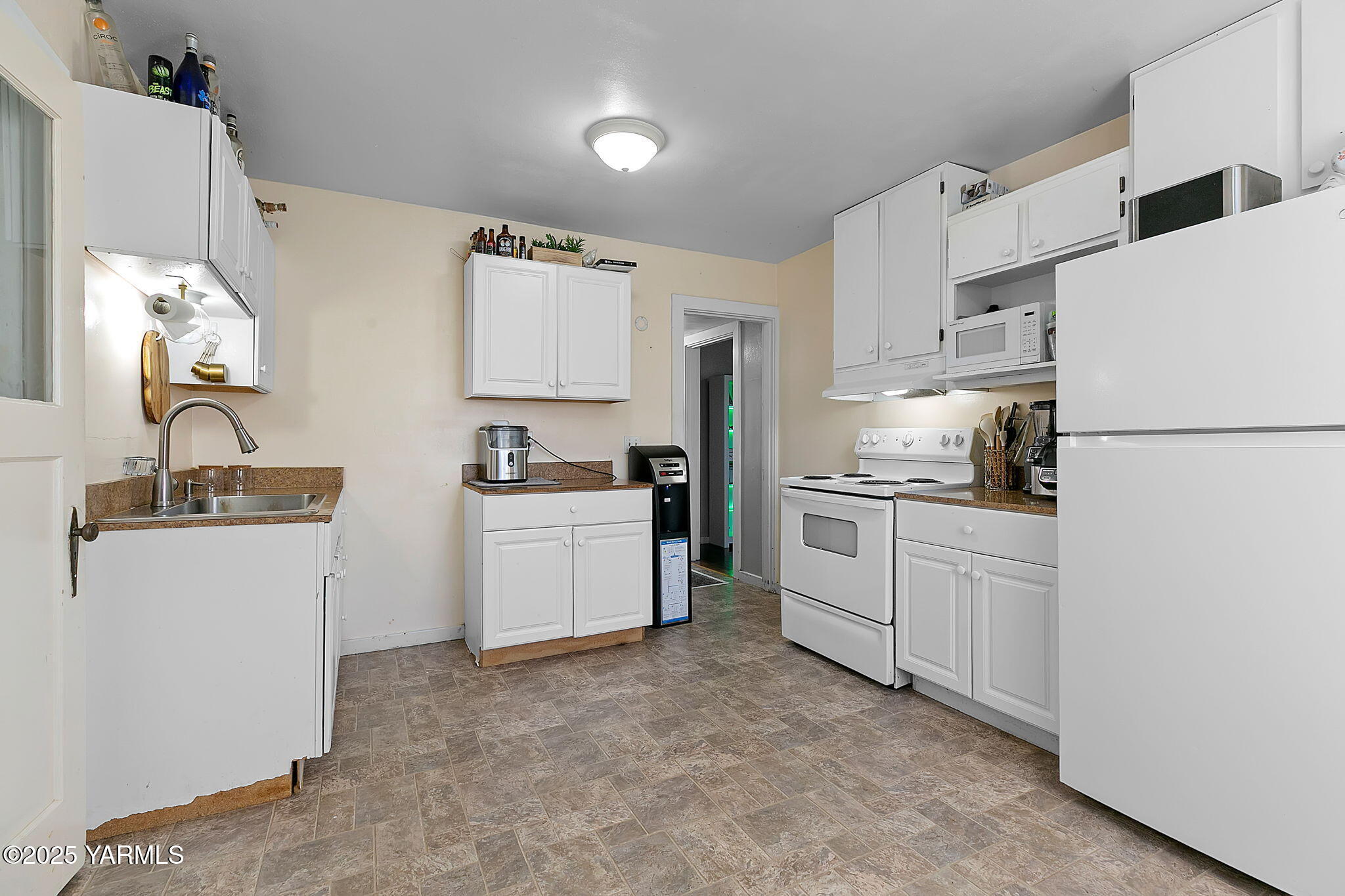 419 West 3rd Street Wapato, WA 98951 - Photo 10 of 19 a kitchen with white cabinets and white appliances