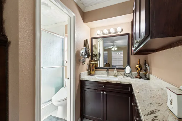 a bathroom with a sink vanity granite and a toilet
