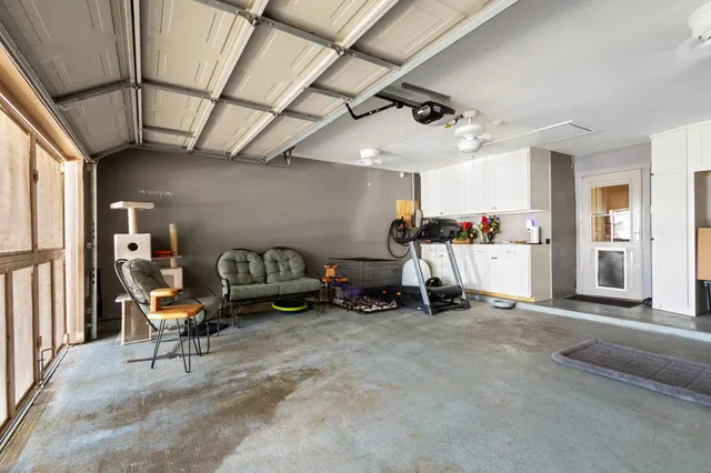 a living room with furniture and a gym machine