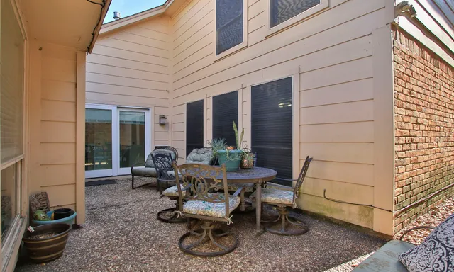 a view of a patio with table and chairs and potted plants