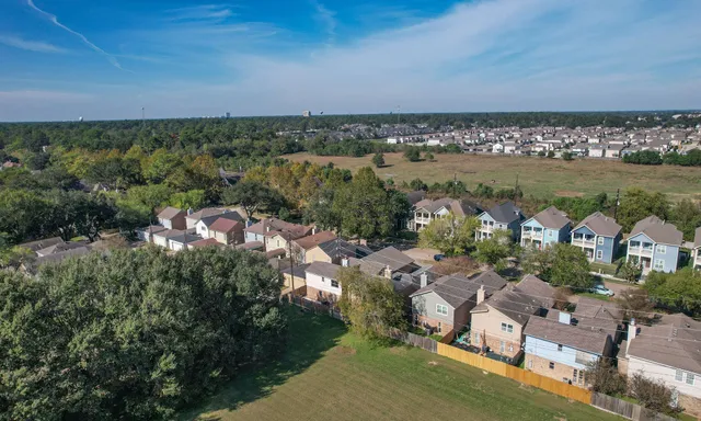 an aerial view of a city with lots of residential buildings ocean and mountain view in back