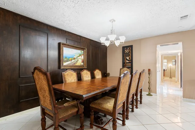a dining room with furniture a chandelier and wooden floor