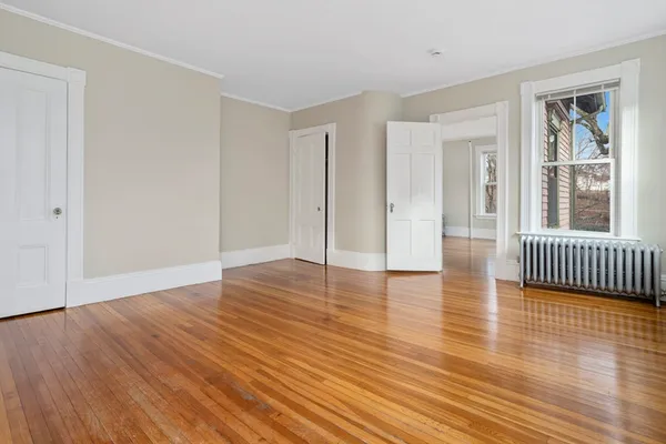 a view of a room with wooden floor and a window