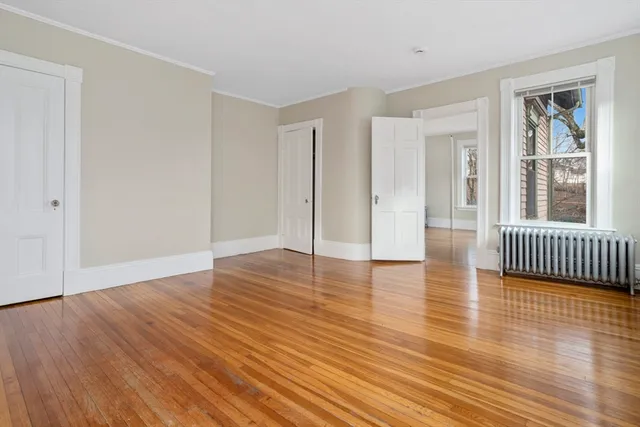a view of a room with wooden floor and a window