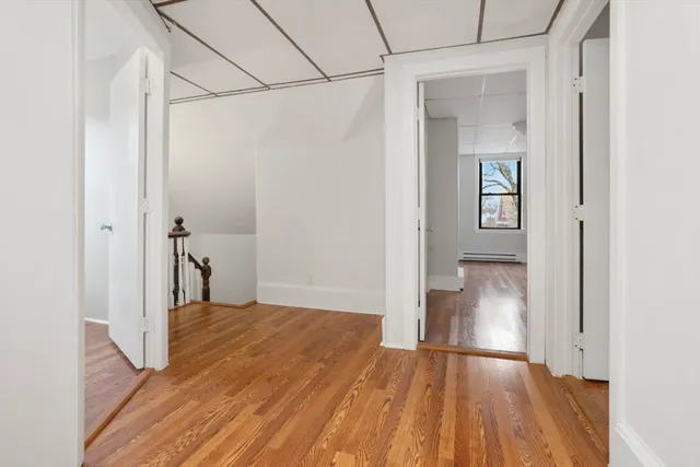 a view of a room with wooden floor and a bathroom