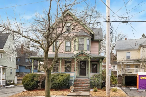 a front view of a building with large tree