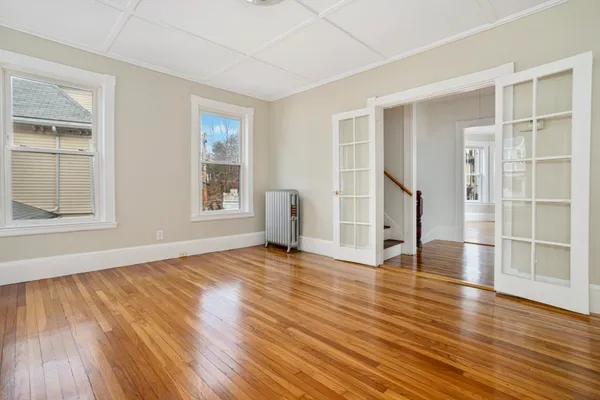 an empty room with wooden floor and windows