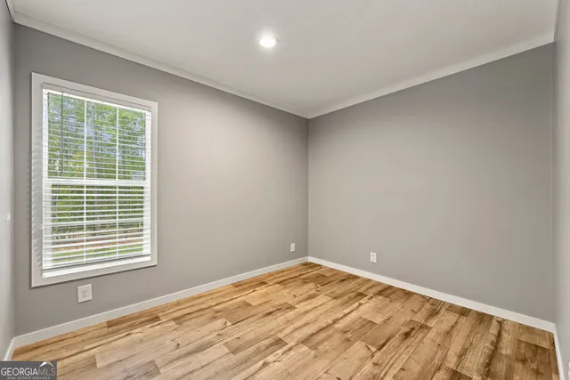 a view of empty room with wooden floor