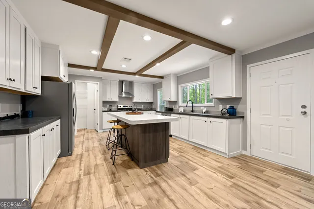 a large white kitchen with stainless steel appliances granite countertop a stove a sink dishwasher and a refrigerator