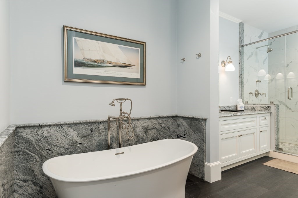 11 Thissell Street, Unit 3 Beverly, MA 01915 - Photo 17 of 31 a bathroom with a white tub a sink and mirror