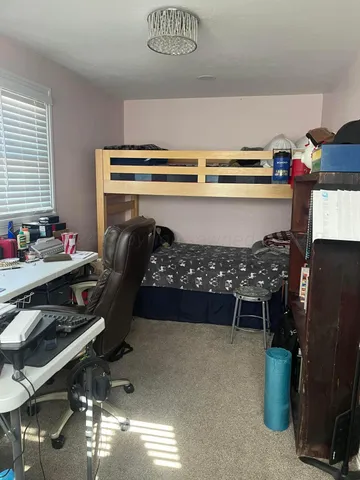 a bed room with a bed and a chair