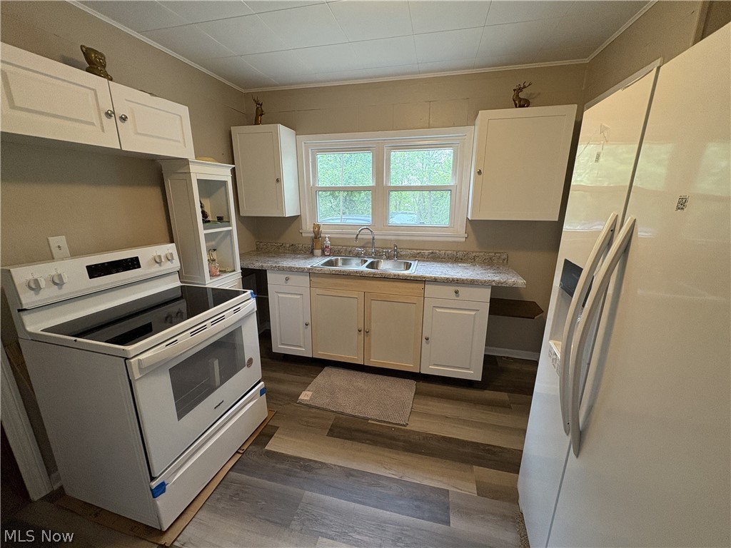 727 Wooster Road North Barberton, OH 44203 - Photo 35 of 37 Studio's Kitchen featuring wood-finish waterproof LVP flooring, white cabinetry, a dual basin stainless steel sink, speckled countertops, new fridge, and a white electric range with a black cooktop
