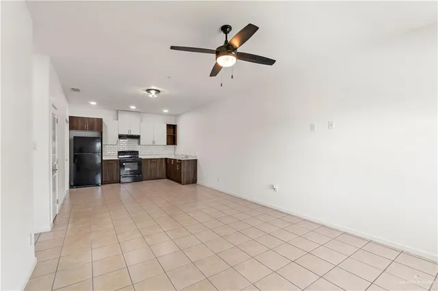 a kitchen with granite countertop a refrigerator and a stove top oven