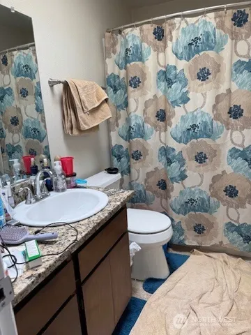 a bathroom with a granite countertop sink and a mirror