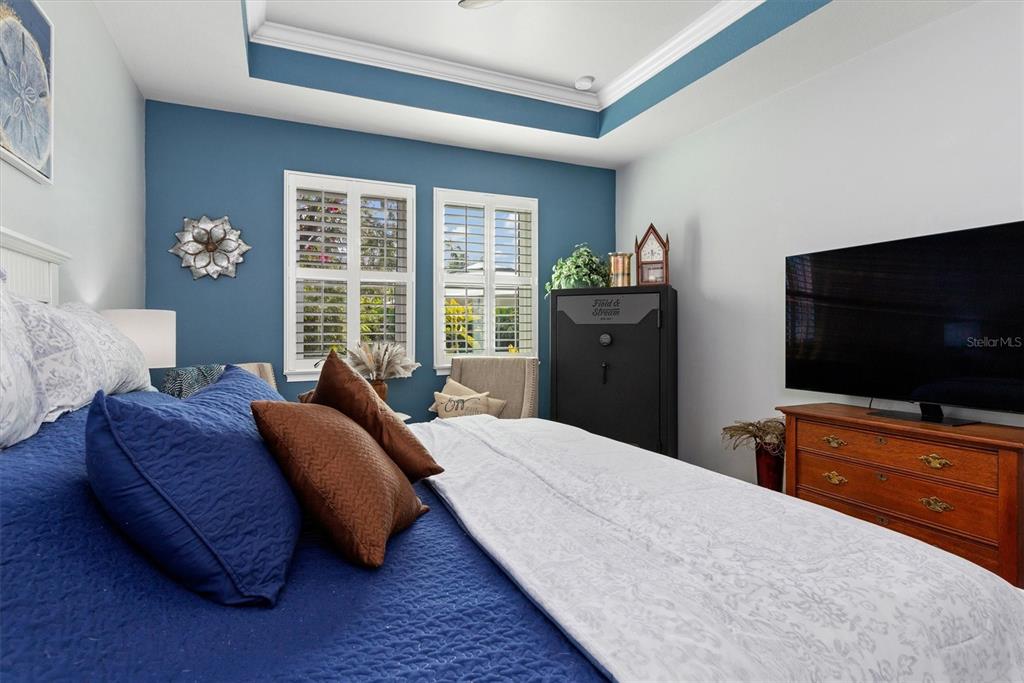 11819 Sistine Lane Venice, FL 34293 - Photo 22 of 90 a bedroom with a bed and a flat screen tv