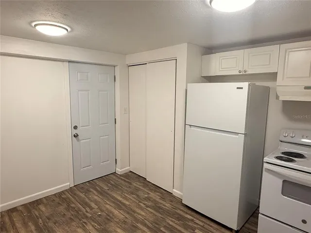 a white refrigerator freezer and a stove sitting inside of a kitchen