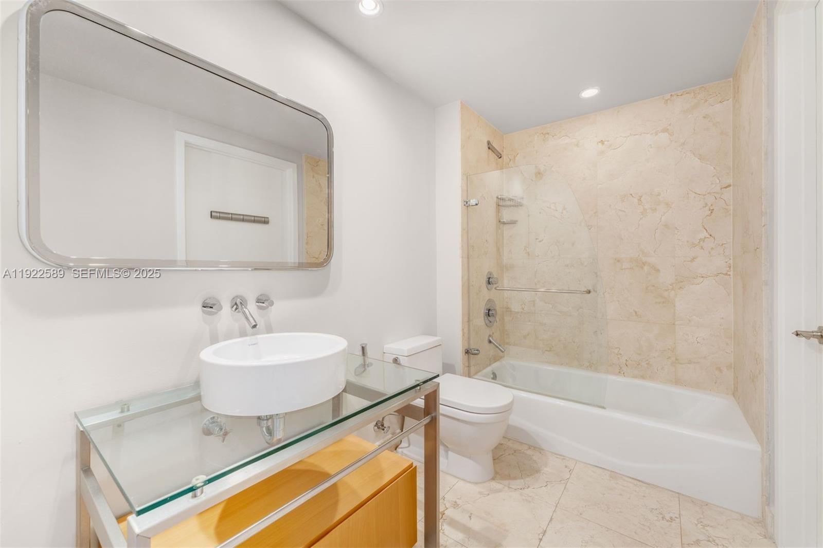 6000 Collins Avenue, Unit 330 Miami Beach, FL 33140 - Photo 14 of 25 a bathroom with a sink a bathtub and a mirror