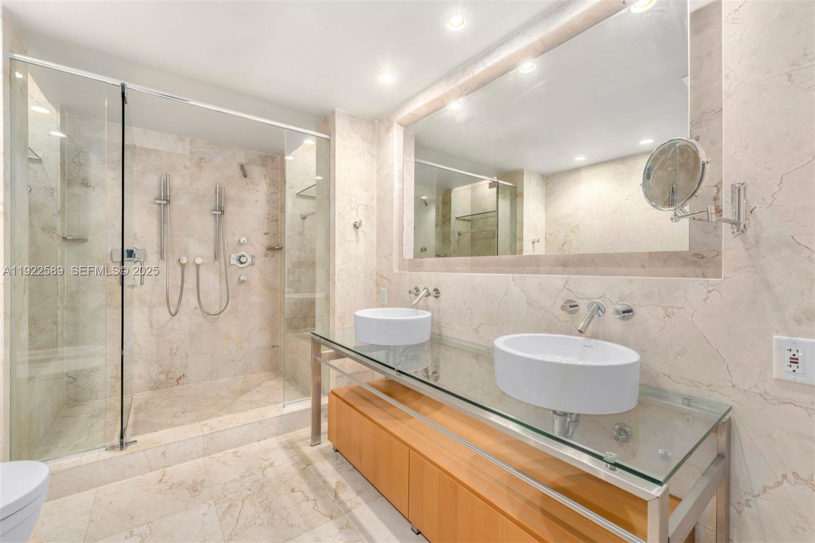 6000 Collins Avenue, Unit 330 Miami Beach, FL 33140 - Photo 21 of 25 a spacious bathroom with a granite countertop sink mirror and shower