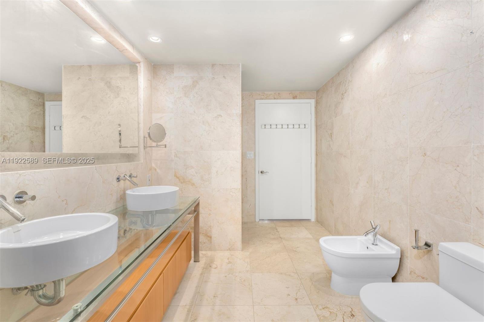 6000 Collins Avenue, Unit 330 Miami Beach, FL 33140 - Photo 23 of 25 a bathroom with a toilet a sink and mirror