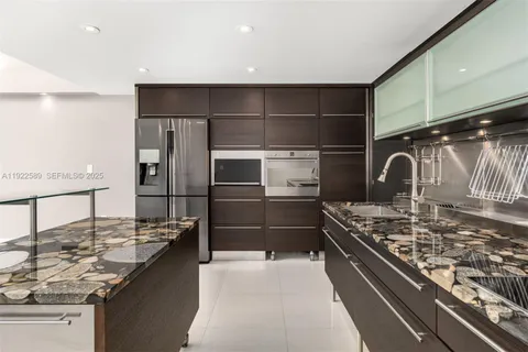 a kitchen with kitchen island stainless steel appliances a sink stove and refrigerator