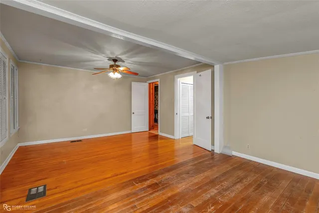 a view of a big room with wooden floor and a ceiling fan