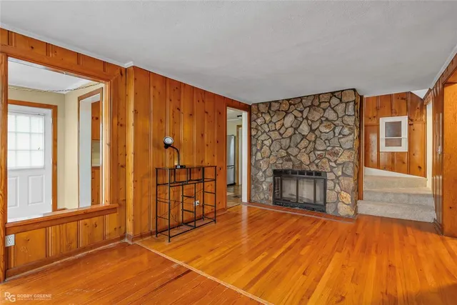 a view of an empty room with a fireplace and wooden floor