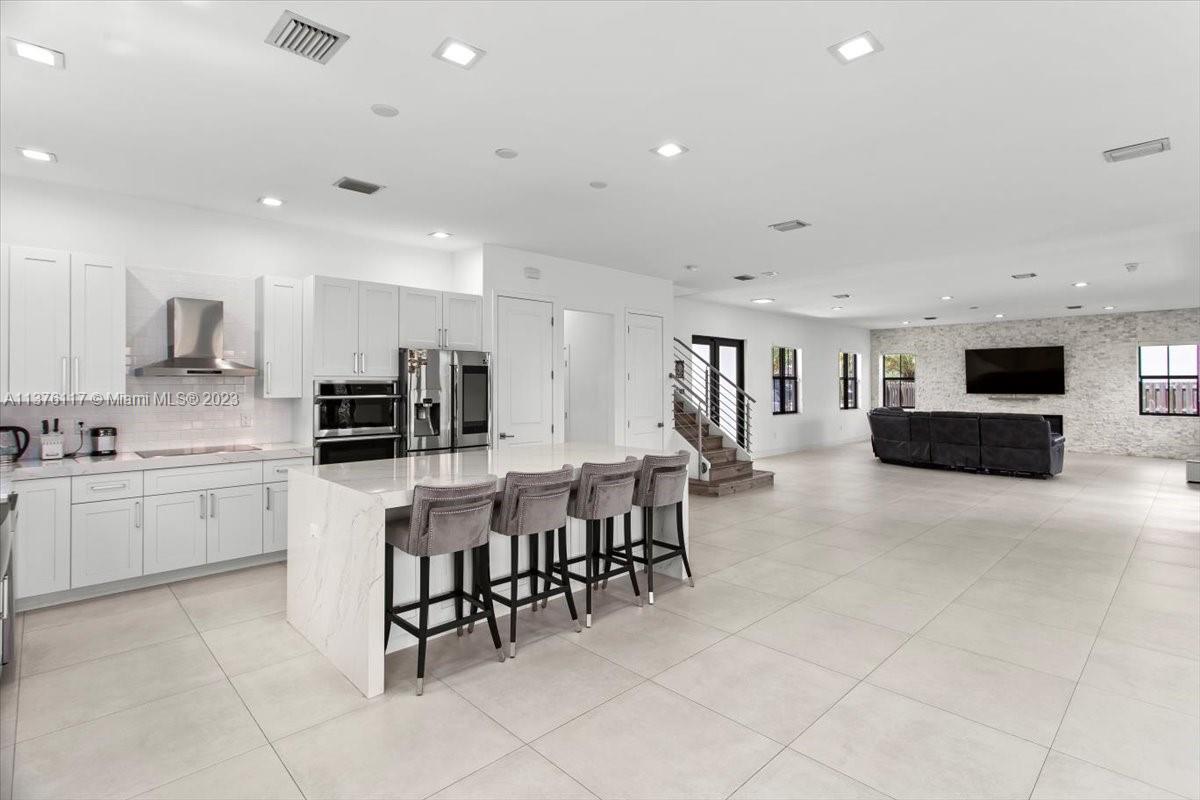 a large white kitchen with lots of counter space and appliances