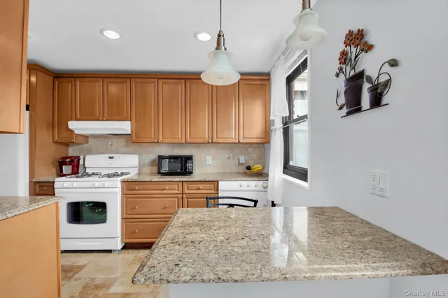 a kitchen with kitchen island granite countertop a sink cabinets and window