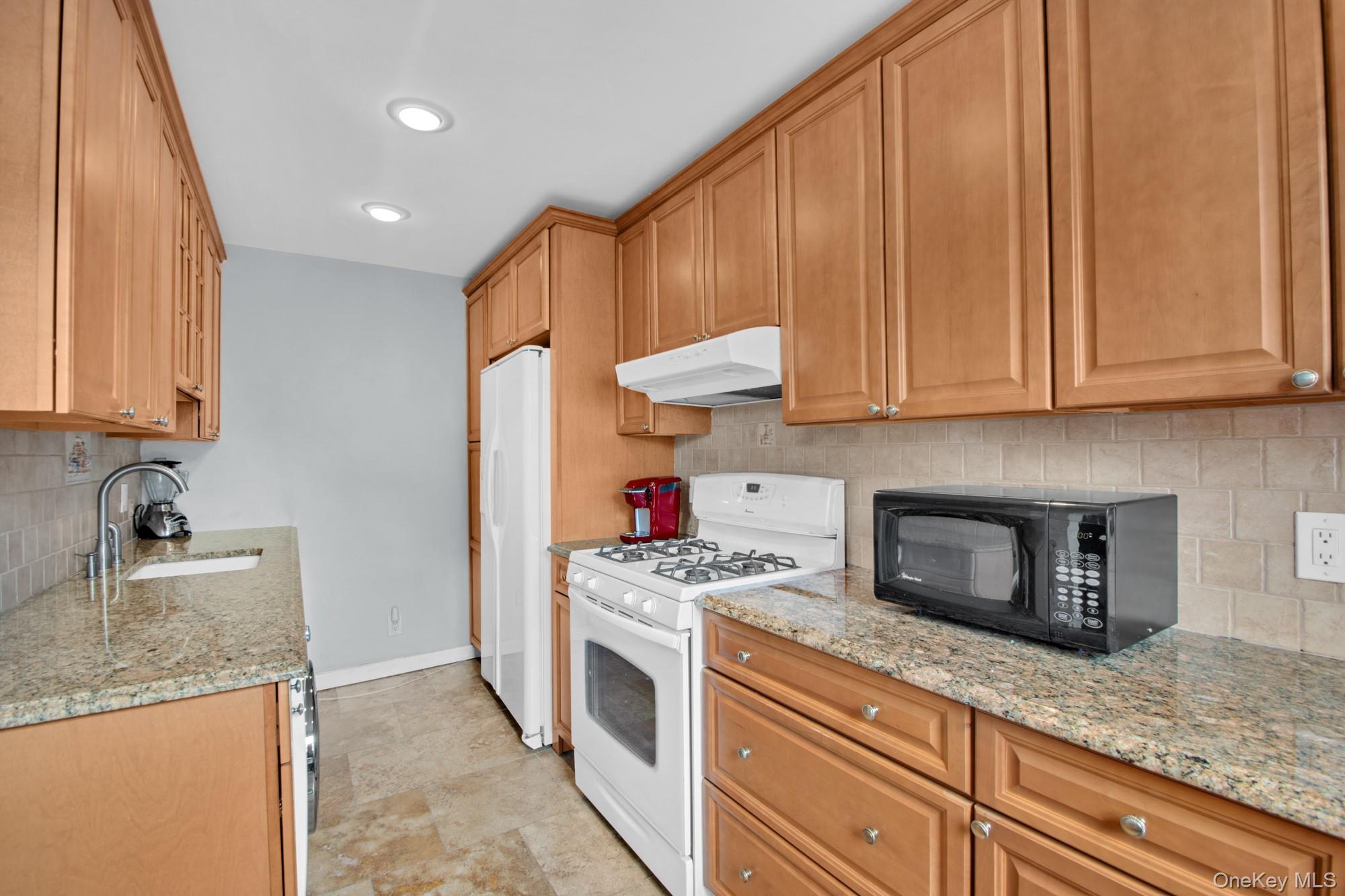 21-29 Utopia Parkway, Unit UPSTAIRS Queens, NY 11357 - Photo 4 of 8 a kitchen with stainless steel appliances granite countertop a sink stove and cabinets