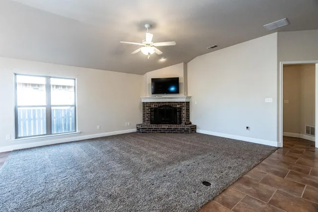 an empty room with windows and fireplace