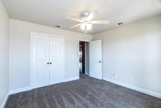 a view of an empty room with a ceiling fan