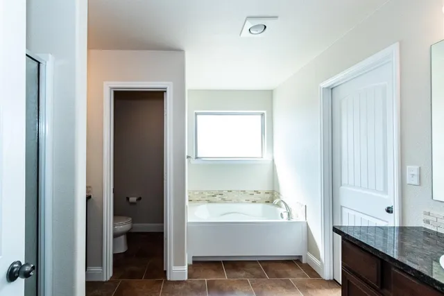a bathroom with a tub shower and sink