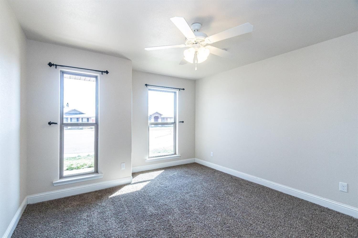 9706 Ridgely Avenue Lubbock, TX 79424 - Photo 23 of 32 an empty room with windows and fan