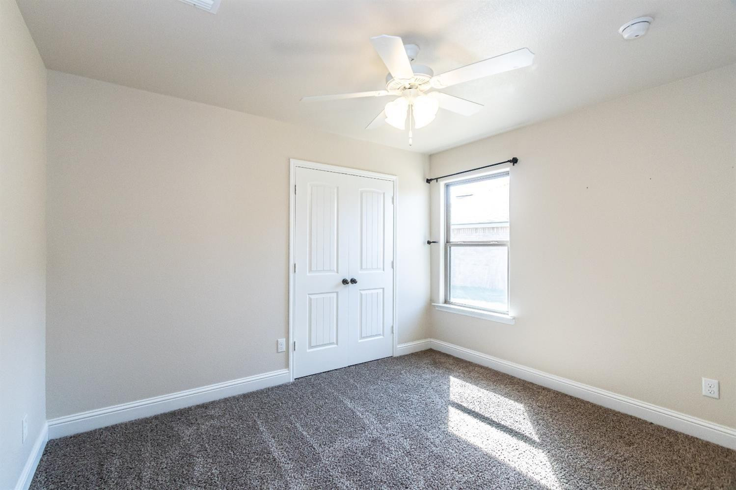 9706 Ridgely Avenue Lubbock, TX 79424 - Photo 24 of 32 an empty room with windows and fan